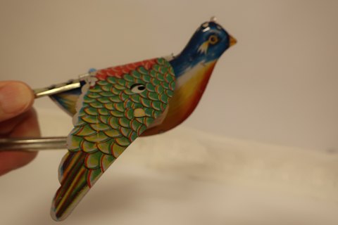 Papagei / "Piepmatz", der mit den Flügeln schlägt und tschilpt
Das schöne alte Spielzeug aus Blech
Drück an das Metal und der Papagei "fliegt"
Total L: 17cm
In sehr gutem Zustand