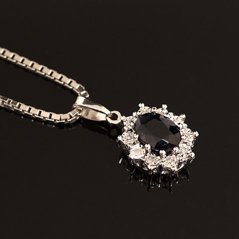 Jørgen Rasmussen, Copenhagen: Pendant of 14ct 
white gold with sapphire and 10 diamonds. Size: 
1x0,8cm. Necklace of 14ct whitegold. L: 46cm