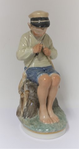 Royal Copenhagen. Porcelain figure. Seated boy in colors. Model 905. Height 19 
cm. (1 quality)