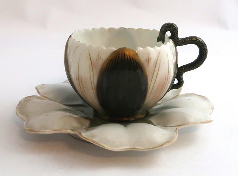 Bing & Gröndahl. Kleine Tasse. Henkel in Schlangenform. Durchmesser der 
Untertasse 11,5 cm. Höhe der Tasse 4,5 cm. Untertasse hat einen Defekt. Siehe 
Foto.