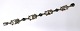 Lundin Antique 
präsentiert: 
Georg 
Jensen. 
Silberarmband 
mit grünen 
Steinen (925). 
Modell 11. 
Länge 18,5 cm. 
...