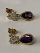 Antik Huset 
presents: 
Gold 
earrings in 14 
carat gold, 
inlaid amethyst 
and clear 
stones.