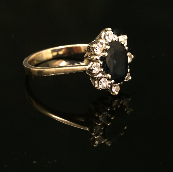 Ring, 14ct, white gold with eight diamonds and a sapphire in the middle