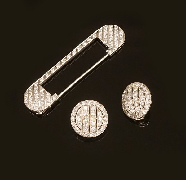 Satz von einer Broche und zwei Ohrclips. Platin mit zahlreichen Diamanten. 
Broche L: 6cm